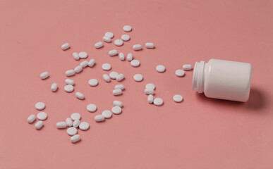 Bottle with pills on pink background. Medical still life