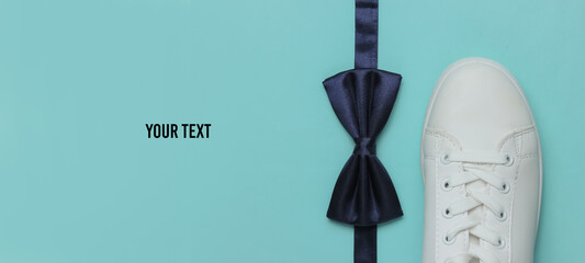 Minimalistic fashion still life, groom look. Stylish white sneakers and a bow tie on blue...