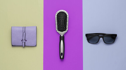 Fashionable women's accessories. Leather wallet, comb, sunglasses on colored background. Top view