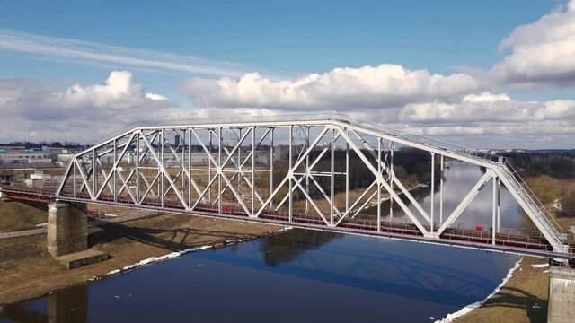 Metal railway train bridge over the river
Belarus Orsha Dnieper River. 
early spring Aerial footage from drone orbital side panorama