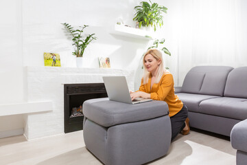 Fototapeta premium Beautiful young woman working on her laptop at home
