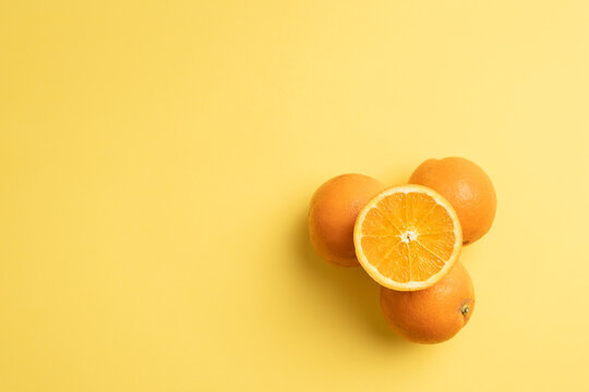 Vitaminas de Fruta naranjas cortadas sobre fondo amarillo liso para texto