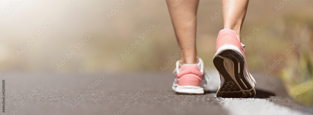 Wall mural Running shoe closeup of woman running on road with sports shoes