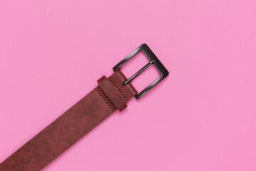 Leather brown belt on pink background