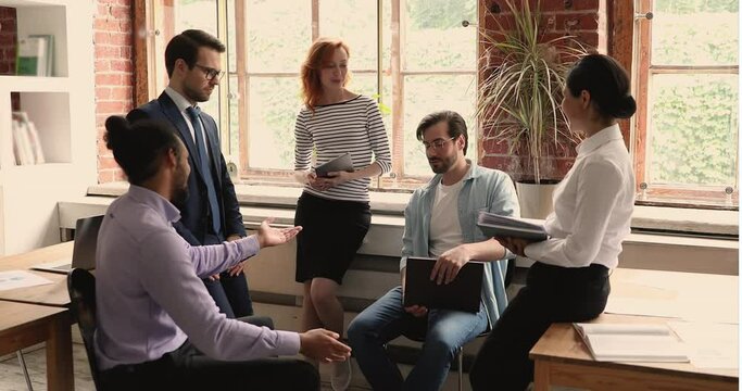 African and Caucasian workmate friendly diverse buddies talking making agreement give high five gesture during group briefing at workplace in office. Make a bet, partnership, support, equality concept