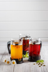 Set of three tea pots on white wooden table