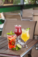 Set of 3 coctails standing on table in summer cafe