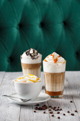 Set of 3 cups of coffee standing on white wooden table