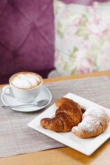 Croissants and cup of hot coffee served on the table