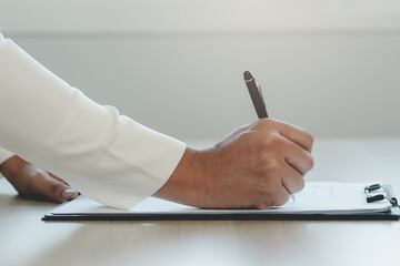 Close up hands of unrecognized person writing on paper