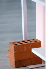 3 brick sitting on a metal leg for balancing purposes