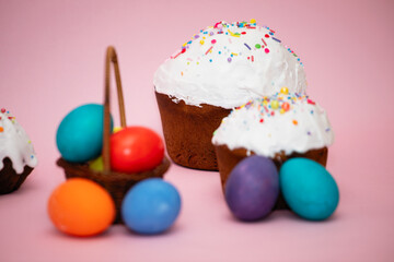 Small basket with beautiful colorful Easter eggs and Easter cakes