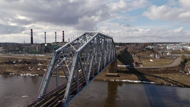 Metal railway train bridge over the river
Belarus Orsha Dnieper River. 
early spring Aerial footage from a drone flying close along the bridge