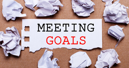 MEETING GOALS written on white paper on a light brown background.