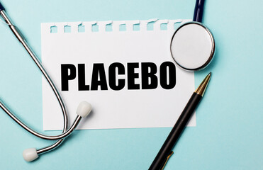 On a light blue background, a stethoscope, a pen and a sheet of paper with the inscription PLACEBO. Medical concept