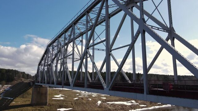 Metal railway train bridge over the river
Belarus Orsha Dnieper River. 
early spring Aerial footage from drone. upward like crane  movement