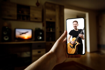 Watching online music performance by the singer at home by smartphone.