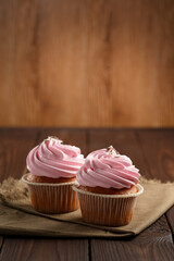 Two tasty cupcakes on wooden table