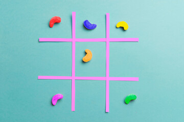 Playing noughts and crosses with colorful cashew nuts. Colorful concept. Minimalist concept.
