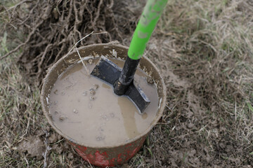 Shallow depth of field (selective focus) details of a dirty shovel during a tree plantation.