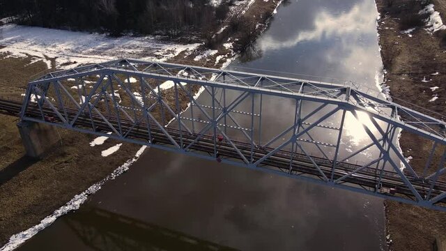 Metal railway train bridge over the river
Belarus Orsha Dnieper River. 
early spring Aerial footage from drone flying above