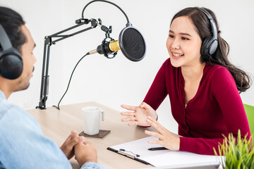 Smile two asian young woman, man radio hosts in headphones, microphone while talk, conversation, recording podcast in broadcasting at studio together. Technology of making record audio concept.