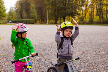 Sweet kids on balance bikes outdoors at the park