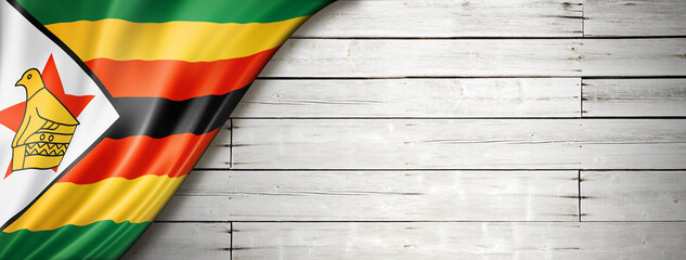 Zimbabwe flag on old white wall banner - obrazy, fototapety, plakaty