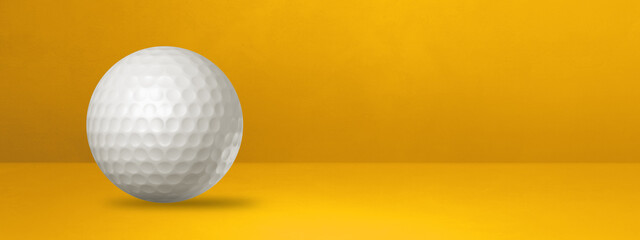 White golf ball on a yellow studio banner