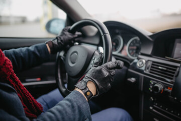 Naklejka premium automotive leather gloves, driver's hands on the steering wheel.
