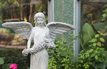 Closeup of angle sculpture decorated in botanic garden.