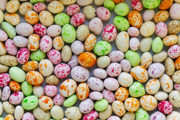 Happy Easter. Lots of colored candy in the form of Easter eggs. Color background. Dragon eggs.