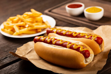Hot dogs with ketchup, yellow mustard and french fries.