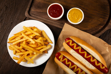 Hot dogs with ketchup, yellow mustard and french fries.