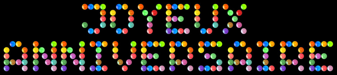 Joyeux anniversaire, bonbons multicolores sur fond noir 