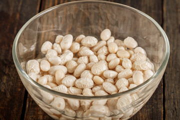 White beans in a clear vase in water ready for cooking. Close-up.