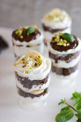 Delicious dessert with chocolate sponge cake, cream cheese and banana. Decorated with pistachios and fresh mint.