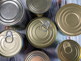 Tin cans with processed food for long-term storage, close-up. Food background with canned food.