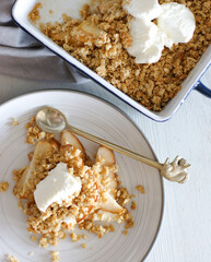 Amazingly delicious crumble with pear and ice cream. Pear pie.