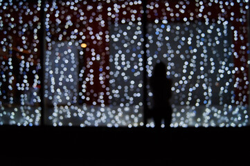 Silhouette of a girl on the background of night city lights. Blurred image