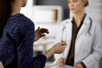 Doctor and patient discussing current health examination while sitting in clinic. Perfect medical...