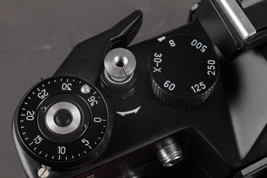 Old film SLR camera, shutter cocking wheel, frame counter and shutter button, close-up, selective focus