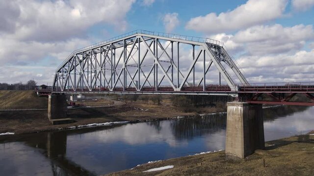 Metal railway train bridge over the river
Belarus Orsha Dnieper River. 
early spring Aerial slow panoramic upward right moving footage from drone