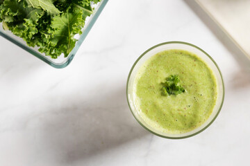 Healthy green kale smoothie with greek yogurt in a glass isolated on white table background, top view. Kale is considered a superfood because it's a great source of vitamins and minerals.