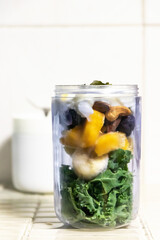 Healthy kale with fruits smoothie in portable blender mixed cashew nut, almond and honey. Kale is considered a superfood because it's a great source of vitamins and minerals.