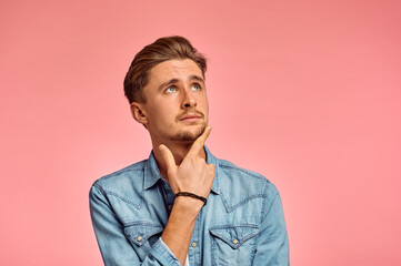 Pensive man portrait, pink background, emotion