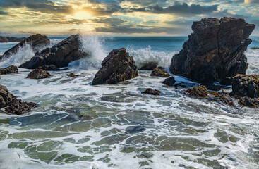 Beautiful seascape of the Pacific coast in California, waves, rocks, sky, sun. Concept, perfect postcard and guide.