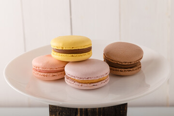 Colorful macaroons on grey mat on white background. Sweet bakery, copy space.