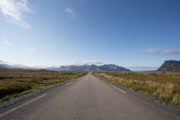 Road leading into the horizon with mountain in the background in Gimsoy, Lofoten, Norway