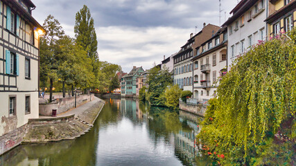 Fototapeta na wymiar View of the old buildings on the riverbanks reflecting on the water, Petite France Strasbourg